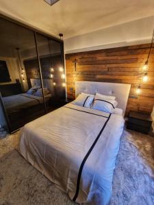 Schlafzimmer mit einem großen weißen Bett und einem Spiegel in der Unterkunft Eclipsei ApartHotel in Popeşti-Leordeni