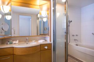 a bathroom with a sink and a mirror and a tub at Sheraton Grande Tokyo Bay Hotel in Urayasu