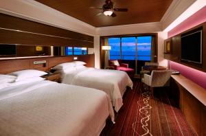 a hotel room with two beds and a large window at Sheraton Grande Tokyo Bay Hotel in Urayasu