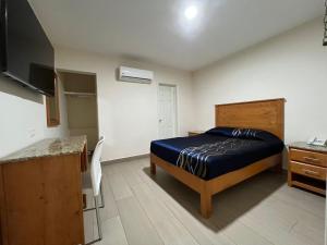 a small bedroom with a bed and a kitchen at Hotel Catalina in Tijuana