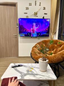 a person sitting in a room with a table and a tv at Smart homestay in Hanoi