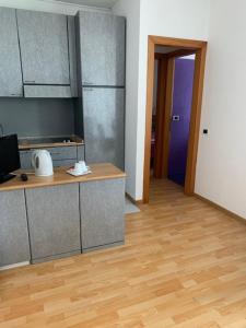 a kitchen with stainless steel cabinets and a wooden floor at Residence Alexandra Stay in Sirmione