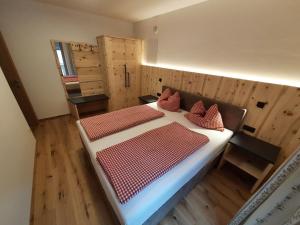 een slaapkamer met 2 bedden in een kamer met houten vloeren bij Hörmannhof in Bressanone