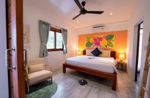 1 dormitorio con 1 cama y 1 silla en ORCHID LODGE SAMUI - Bed & Breakfast en Lamai Beach