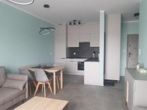 a kitchen and living room with a couch and a table at Apartament ul. Marzeń in Kostrzyn nad Odrą
