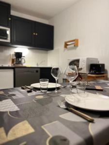 een tafel met borden en glazen bovenop een keuken bij Appartement aux portes de Megeve in Praz-sur-Arly