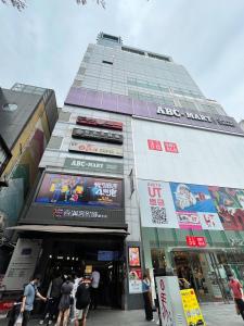 台北市にある西門雲町旅店 Sky Gate Hotelの目の前を歩く人々のいる高い建物