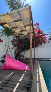 a pink umbrella laying on a deck next to a pool at Villa Luna Sunset Beach in Gili Trawangan