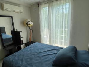 ein Schlafzimmer mit einem Bett und einem großen Fenster in der Unterkunft Acapulco Marina Diamante in Acapulco