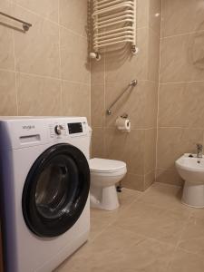 een badkamer met een wasmachine en een toilet bij Apartament przy plaży in Kołobrzeg