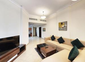 a living room with a couch and a flat screen tv at RH- Modern Urban Oasis, 02RB near mall of Emirates in Dubai