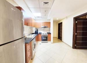 duża kuchnia z drewnianymi szafkami i urządzeniami w obiekcie RH- Modern Urban Oasis, 02RB near mall of Emirates w Dubaju