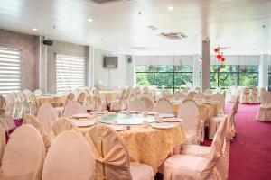 een banketzaal met tafels en stoelen en een tafeltennistafel bij Flemington Hotel in Taiping