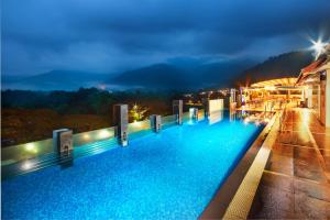 a hotel swimming pool at night with a view at Flemington Hotel in Taiping