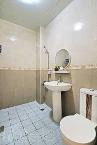 ein Badezimmer mit einem Waschbecken, einem WC und einem Spiegel in der Unterkunft 有風小院 in Green Island