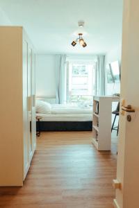 a bedroom with a bed and a desk in a room at Apartment modern und gemütlich ggü. Uni-Passau, TG-Stellplatz, Balkon in Passau