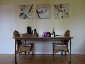 a table with two chairs and a bottle of wine at L'Enclos B&B in Châtillon-en-Diois