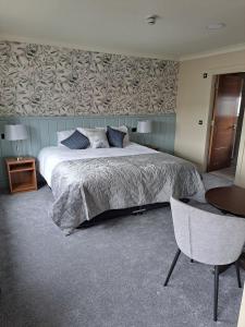 a bedroom with a bed and a table and a chair at The Coachmans Inn in Roscommon