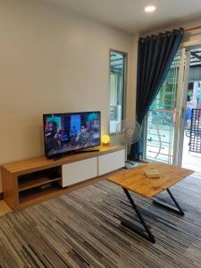 salon z telewizorem z płaskim ekranem i stolikiem kawowym w obiekcie cross 4 w Phuket