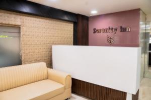 a waiting room with a couch and a company sign at Treebo Trend Serenity Inn in Pune