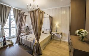 a bedroom with a canopy bed and a window at Casa Andrea in La Morra