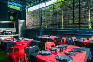 a dining room with red tables and red chairs at Treebo Trend Serenity Inn in Pune