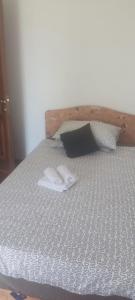 Una cama con dos zapatillas blancas encima. en Villa Fiumana, en Rijeka
