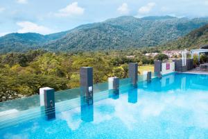 a swimming pool with mountains in the background at Flemington Hotel in Taiping