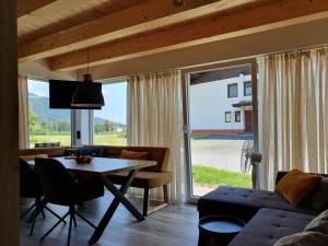 ein Wohnzimmer mit einem Tisch und einem großen Fenster in der Unterkunft Alpensuss in Kötschach