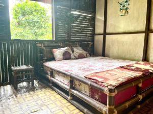 a bedroom with a bed and a table in it at Batu Kapal Lodge in Bukit Lawang