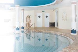a swimming pool in a house with a ceiling at Hotel Schneider Dependance in Obertauern