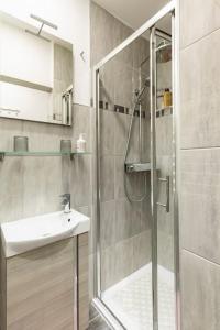 uma casa de banho com um chuveiro e um lavatório. em Marinianis Premium Apartment em Zagreb