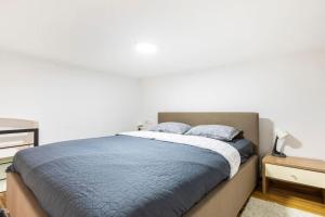 um quarto com uma cama com lençóis e almofadas azuis em Marinianis Premium Apartment em Zagreb
