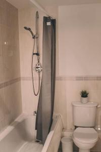 a bathroom with a toilet and a shower with a shower curtain at Spacious 2 bedroom apartment in Central Oxford in Oxford