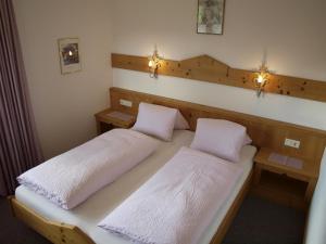2 camas en una habitación con luces en la pared en Haus Moosplatzl en Leutasch