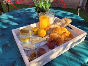 una bandeja de comida en una mesa con pan y zumo de naranja en Effet Mer, 4 etoiles, gîte de 80m2 en Dorlisheim