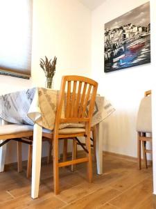 uma mesa de jantar com uma cadeira de madeira, uma mesa de madeira e uma mesa de mesa; em Studio apartman Barbeta em Grebaštica