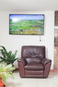 brązowa skórzana kanapa w salonie z telewizorem z płaskim ekranem w obiekcie A V Residency w mieście Koczin