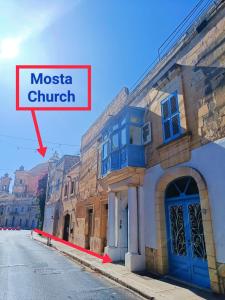 un edificio con un cartello che legge la chiesa del museo di Fusion Homestay Accommodation a Mosta