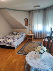 sypialnia z łóżkiem i stołem z wazonem kwiatów w obiekcie Marytilla w Budapeszcie