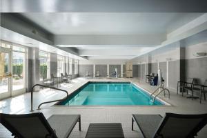 a pool in a hotel with chairs at Residence Inn Philadelphia Conshohocken in Conshohocken