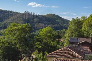 widok na góry z drzewami i domami w obiekcie Casa Azul De Perlleces w mieście Cangas de Onís