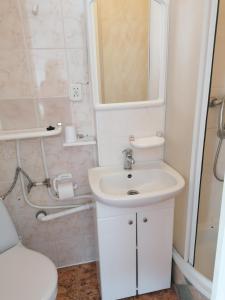 a white bathroom with a sink and a mirror at Villa pod Topolami in Okuninka +32 photos