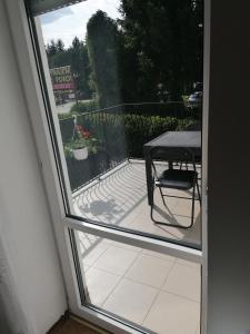 a glass door with a table and a chair on a patio at Villa pod Topolami in Okuninka