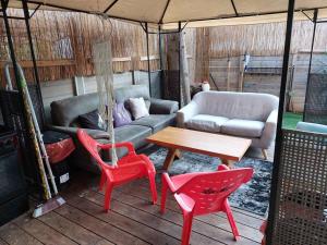 porche con sofá, sillas y mesa en Luxury Jacuzzi Near Beach, APT with 80sq garden, en Bat Yam
