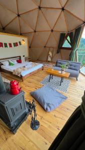 a room with a yurt with a couch and a stove at North Dome & Suite in Rize