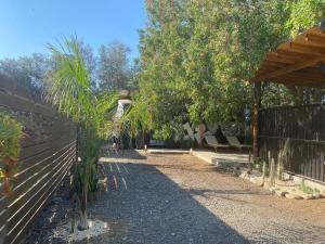 a garden with a fence and a bench and trees at - Magic Bus - in Chlorakas