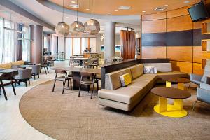 a lobby with a couch and tables and chairs at Springhill Suites by Marriott Savannah Downtown Historic District in Savannah