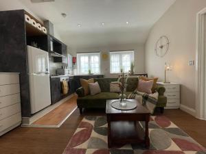 a living room with a green couch and a coffee table at Cozy Retreat in Luton in Luton