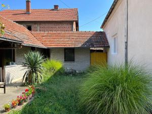 une maison avec un toit rouge et quelques plantes dans l'établissement Kobran, à Kuršumlija